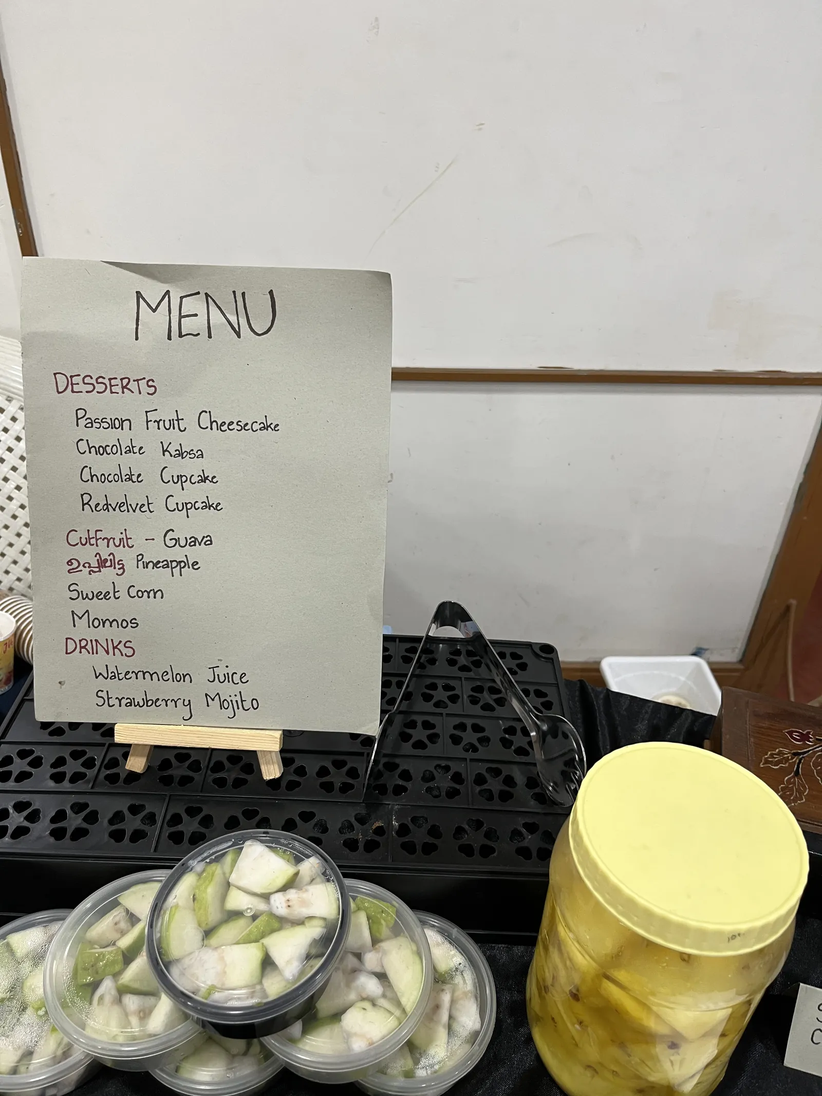 The day's menu, handwritten: desserts, cut fruit and drinks.